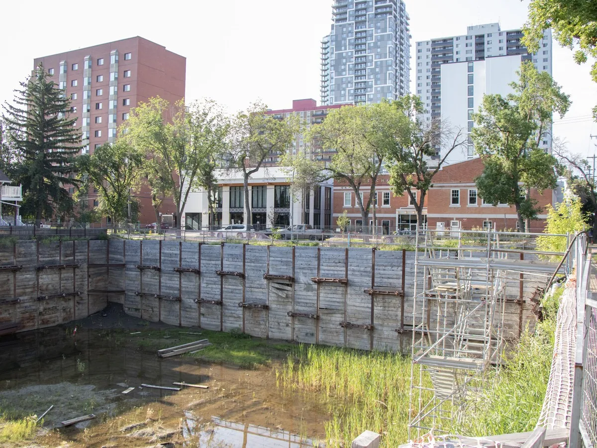 Downtown Edmonton's abandoned construction pit poses safety risks as water, overgrowth worsen